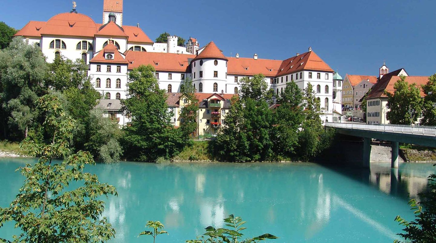 Füssen - Kreuzweg des Märchenkönigs  Nicht einfach zu finden, der Aufstieg: Gegenüber der Füssener Altstadt geht’s gleich neben der Landstraße Richtung Österreich ab ins Gebüsch. Ein steiler Kreuzweg führt den 933 Meter hohen Kalvarienberg hinauf. Vom Gipfel hat man ein einmaliges Rundumpanorama über Alpen und Alpenvorland, die gemusterten Dächer der Füssener Altstadt und Neuschwanstein. Sicher der schönste Ort, um das Märchenschloss samt Kulisse zu bestaunen. König Ludwig II. Wusste das – er ging oft bei der Karfreitagsprozession mit.  www.fuessen.de  Auf der Lokalpatrioten-Karte anschauen