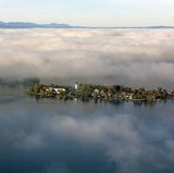 Chiemsee - Insel des Schweigens  Die Benediktinerinnen auf der Fraueninsel im Chiemsee – 12 Hektar groß, 300 Einwohner – leben einen dörflichen, bayerischen Katholizismus. Dass im Refektorium Ayurveda-Gerichte aus den Töpfen eines indischen Kochs aufgetragen werden, ist kein Widerspruch. In Sichtweite des Eilands: die Herreninsel, wo der spinnerte Bayernkönig Ludwig einen Versailles-Nachbau errichtete. Auf der Fähre zur Insel summen viele Sprachen. Nach dem Anlegen ist Ruhe. Schnell in die Kapelle. Sitzen, lesen, schweigen. Danke, Schwestern.  www.frauenwoerth.de  Auf der Lokalpatrioten-Karte anschauen
