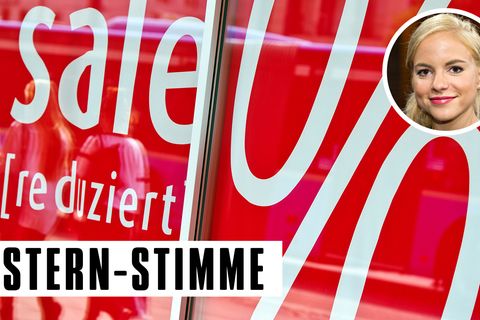 In einem Schaufenster mit einem Sommerschlussverkauf-Plakat spiegeln sich Passanten
