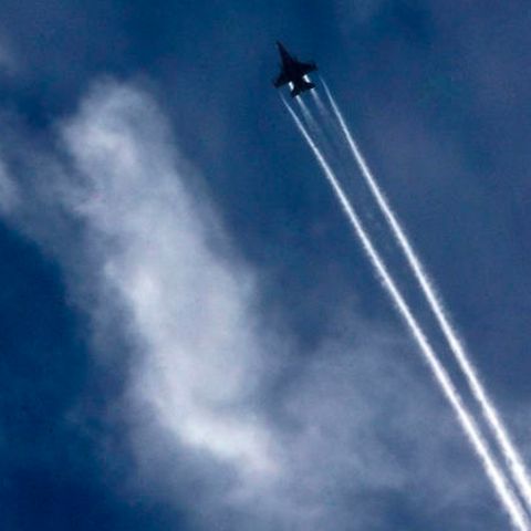 Ein Kampfjet vor bewölktem Himmel, zieht Kondensstreifen nach sich