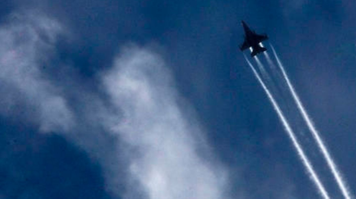 Ein Kampfjet vor bewölktem Himmel, zieht Kondensstreifen nach sich
