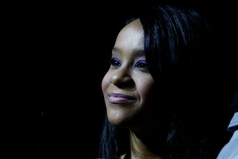 Bobbi Kristina Brown blickt im Halbdunkel vor einem tiefschwarzen Hintergrund nach oben.