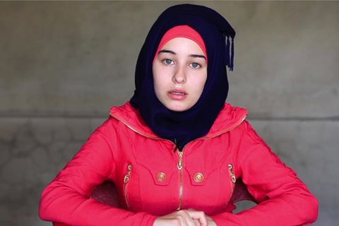 Die 18-Jährige trägt einen roten Anorak und ein schwarzes Kopftuch