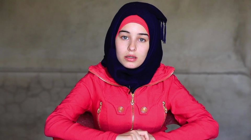 Die 18-Jährige trägt einen roten Anorak und ein schwarzes Kopftuch