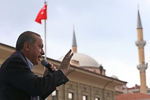 Präsident Tayyip Erdogan spricht in Eskisehir vor einer türkischen Flagge in ein Mikrofon und gestikuliert.