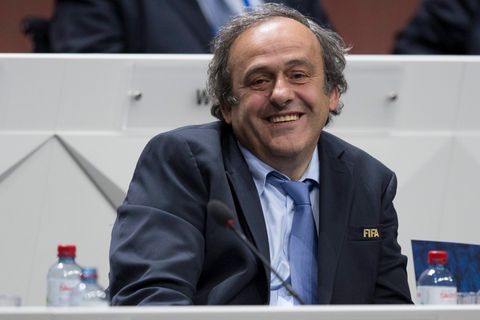 Michel Platini im Anzug an einem Rednerpult