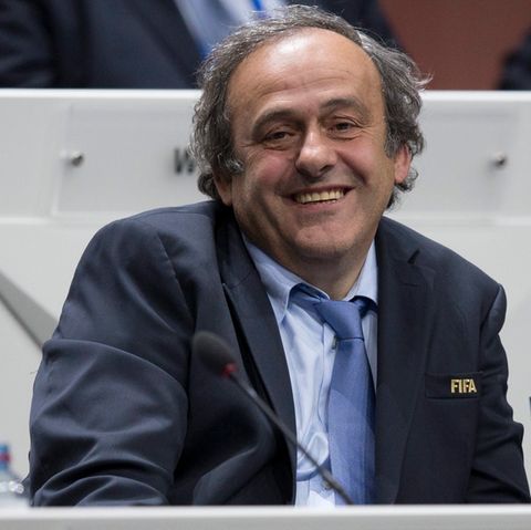 Michel Platini im Anzug an einem Rednerpult