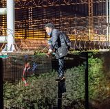 Flüchtlinge am Eurotunnel: Um an den Tunnel heranzukommen, klettern die Menschen über Zäune und Gitter.