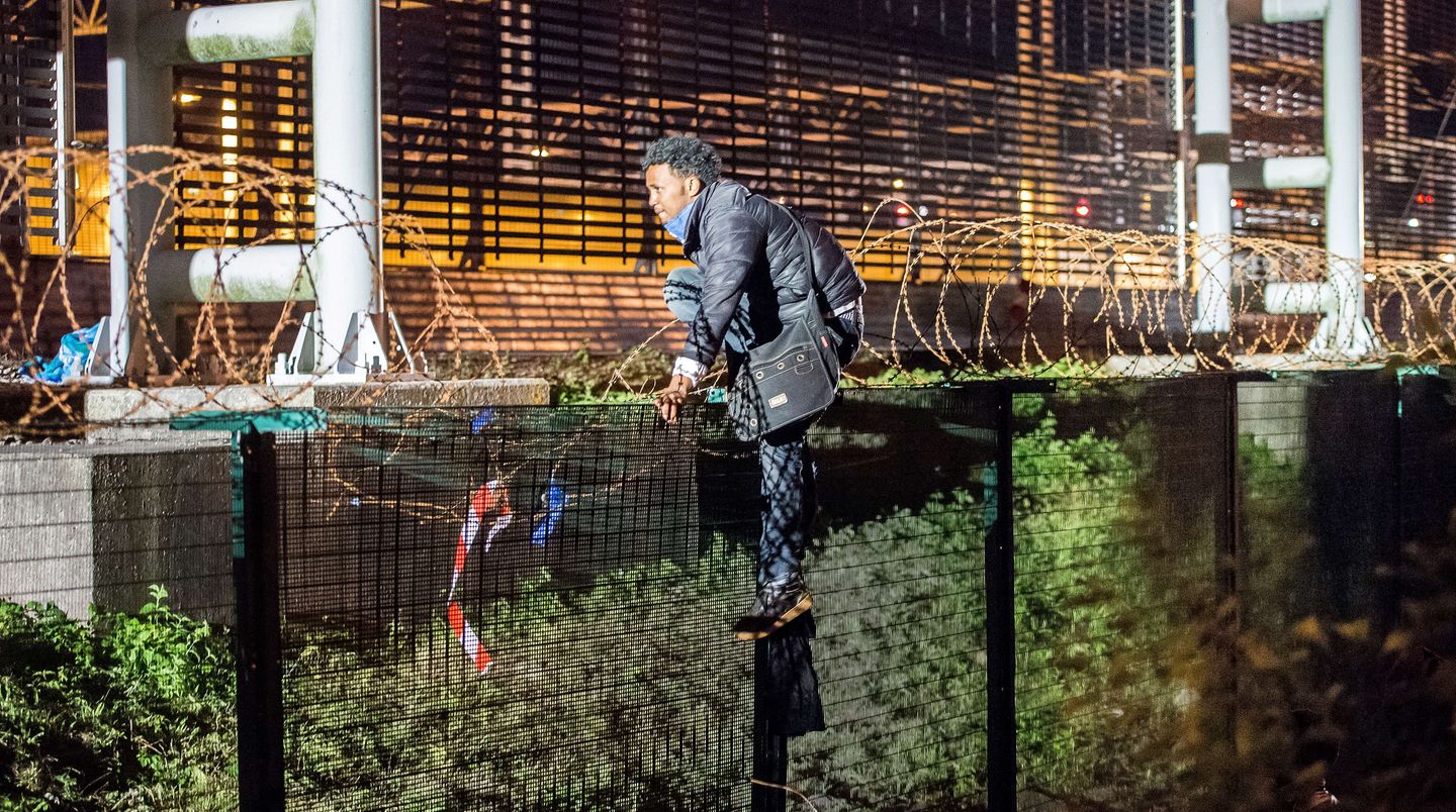 Flüchtlinge am Eurotunnel: Um an den Tunnel heranzukommen, klettern die Menschen über Zäune und Gitter.