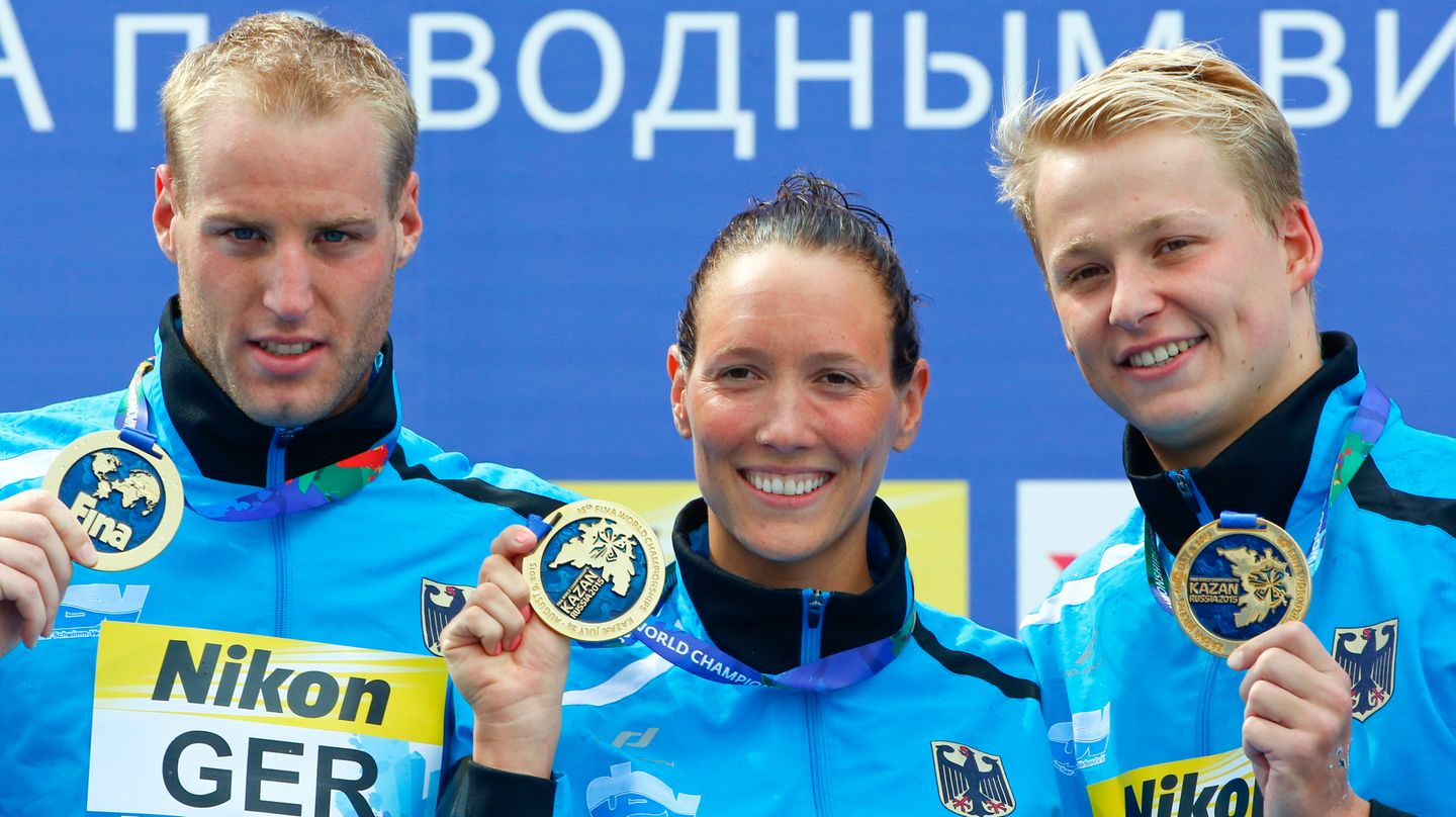 Die Freiwasser-Schwimmer Christian Reichert, Isabelle Härle und Rob Muffels zeigen ihre Goldmedaillen