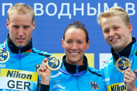 Die Freiwasser-Schwimmer Christian Reichert, Isabelle Härle und Rob Muffels zeigen ihre Goldmedaillen