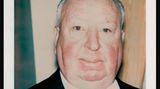 Alfred Hitchcock in Anzug und Krawatte vor unebenem Hintergrund.