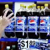 Einige Pepsiflaschen stehen im Verkaufsregal