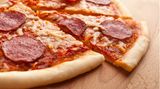 Eine geschnittene Pizza mit Salami