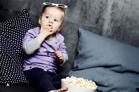 Kleines Kind isst Popcorn und schaut einen Film