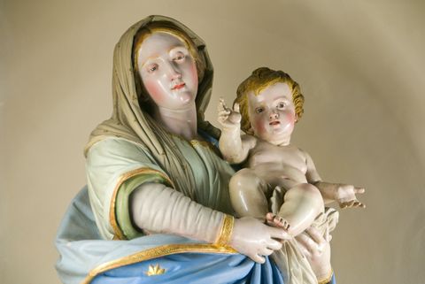 Ein hölzernes Jesuskind liegt im Arm einer Madonnenfigur