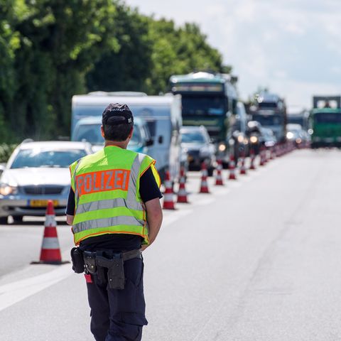 Ein Polizist kontrolliert auf einer Autobahn