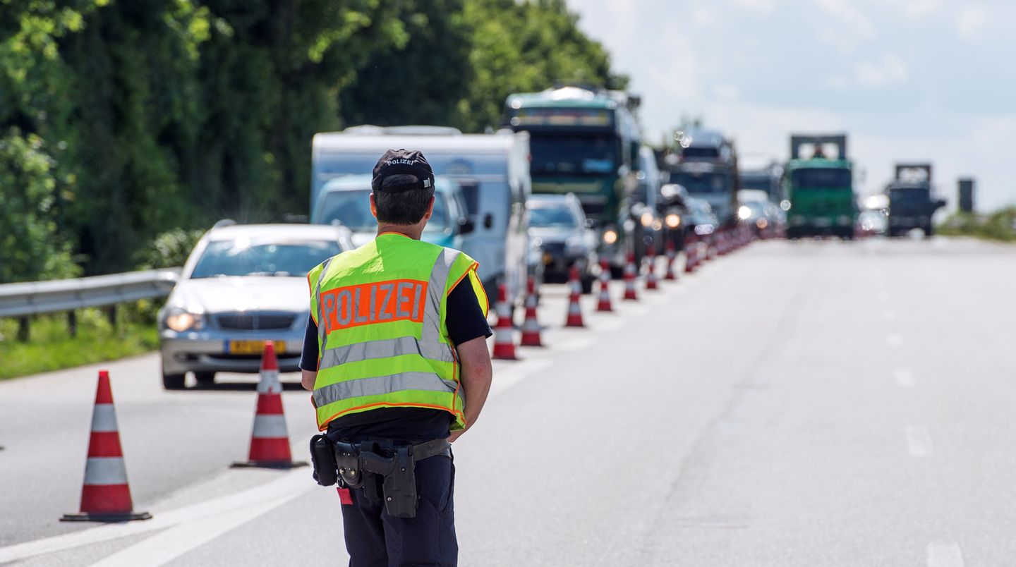 Ein Polizist kontrolliert auf einer Autobahn