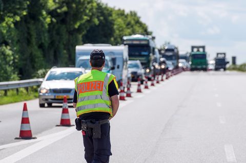 Ein Polizist kontrolliert auf einer Autobahn