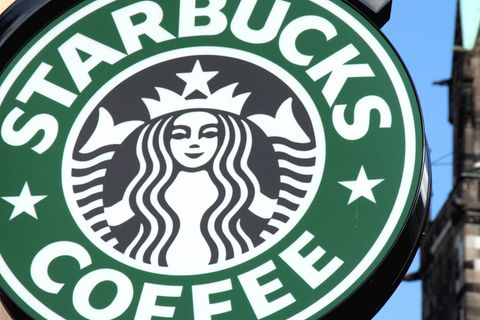 Das grüne Starbucks-Logo mit der schwarzen Nixe