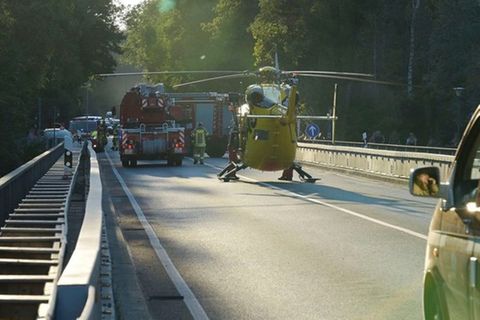 Einsatzkräfte stehen auf einer Brücke über der Isar.