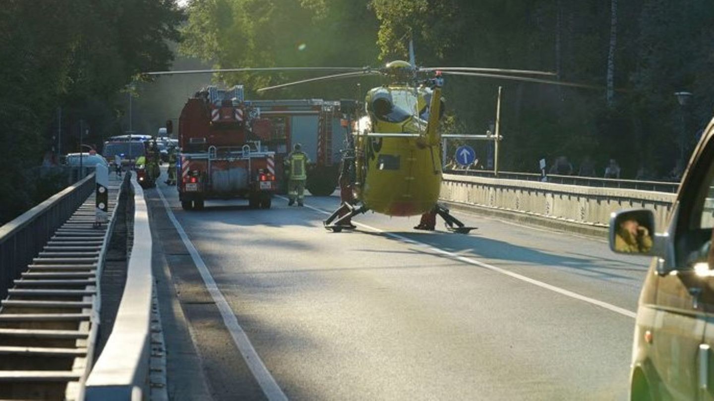 Einsatzkräfte stehen auf einer Brücke über der Isar.