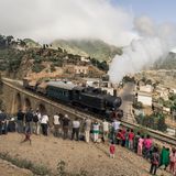 Der Zug bei der Überfahrt der Brücke in Arbaroba, Eritrea am 06.12.2014. Im Vordergrund stehen Teilnehmer der Reisegruppe und fotografieren den Zug.