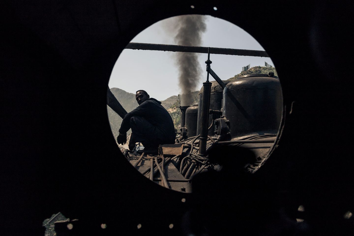 Der Zug macht am 06.12.2014 in Arbaroba, Eritrea Halt, um Wasser aufzunehmen. Blick aus dem Führerhaus während ein Lokführer auf der Lok sitzt. 