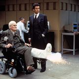 Qs richtiger Name ist Major Boothroys. Ian Fleming erfand die Figur als Dank an Geoffrey Boothroyd, einem Waffenexperten, der dem Autor emfpahl, Bonds Baretta 148 gegen eine Walter PPK auszutauschen. Denn die Baretta sei eigentlich eine "Frauenwaffe", erklärte der Experte.