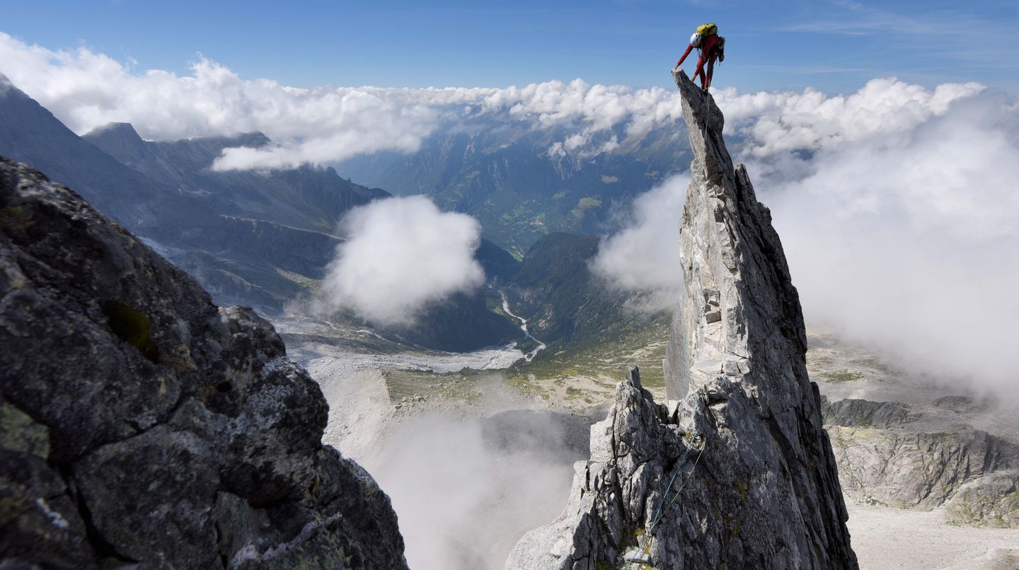 Alpinist auf Felsnadel Alpinist auf Felsnadel