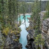 Wanderer sitzt auf einer Klippe über einem See