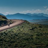 Biker auf unasphaltierter Straße bergauf