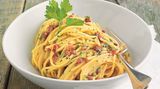 Ein Teller mit dampfender Pasta alla carbonara - ein Klassiker