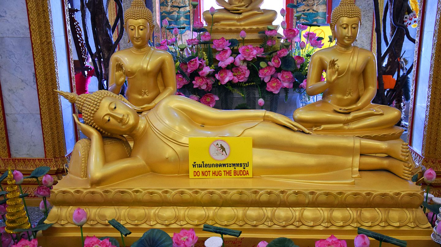 Liegender Buddha mit Schild "Do not hug the buddha"