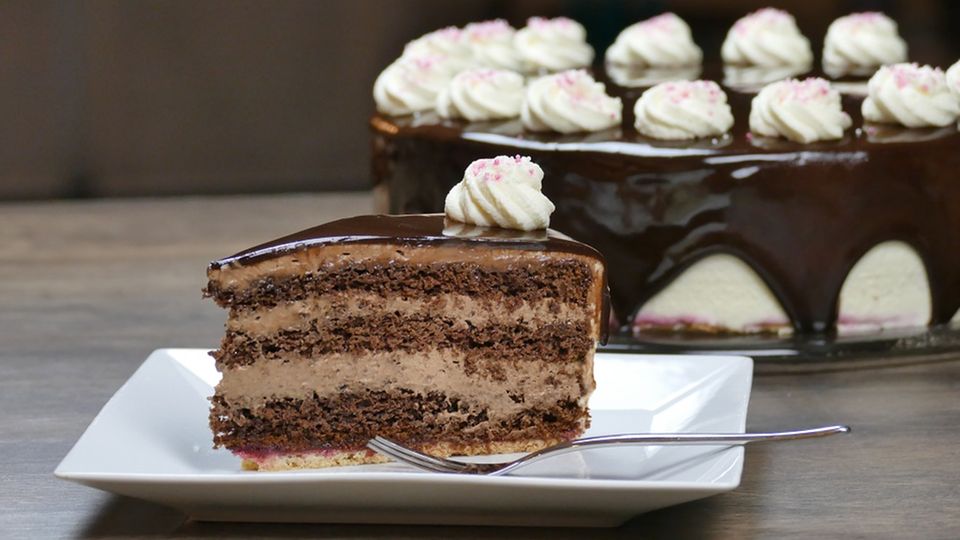 Ein Stück Schoko-Sahne-Torte auf quadratischem weißen Teller mit Gabel
