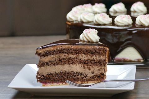 Ein Stück Schoko-Sahne-Torte auf quadratischem weißen Teller mit Gabel