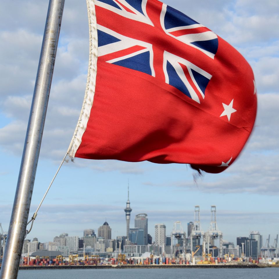 Annäherung an Auckland: Auf dem Rückweg taucht die Silhouette der Stadt auf, überragt vom 328 Meter hohen Sky Tower. Im Vordergrund flattert die rote Nationalflagge Neuseelands mit britischem Union Jack. In einem Referendum Mitte März hatte sich die Mehrheit der Bevölkerung gegen ein neues Design mit einem Silberfarn ausgesprochen.