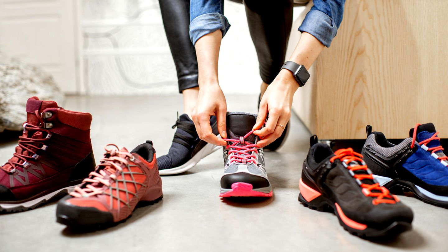 Eine Frau sitzt auf einem Sofa und probiert Schuhe an