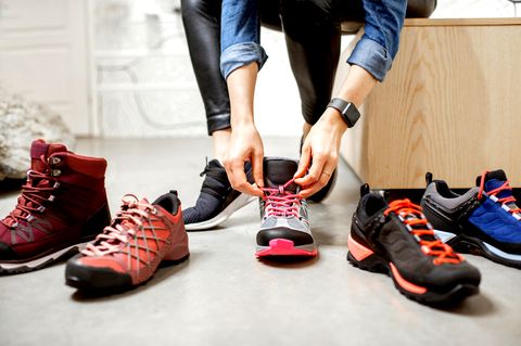 Eine Frau sitzt auf einem Sofa und probiert Schuhe an
