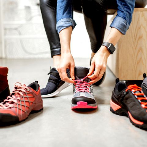 Eine Frau sitzt auf einem Sofa und probiert Schuhe an