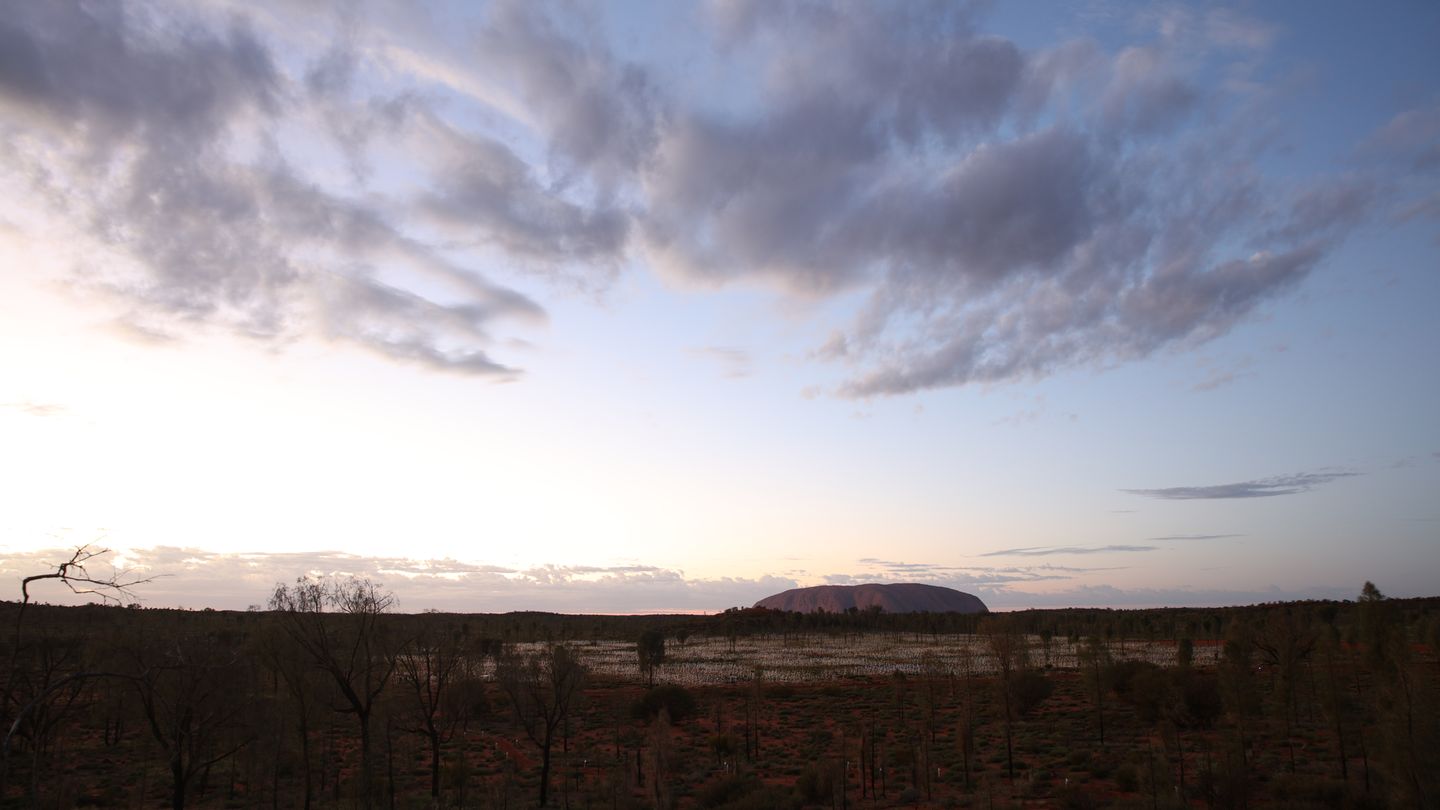 Ort der Installation ist die Wüste vor dem Uluru: Der sich 350 Meter aus der Ebene erhebende Felsen gilt als heiliger Berg der Aborigines