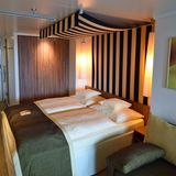 Doppelbett mit Baldachin in einer Verandakabine der AidaPrima