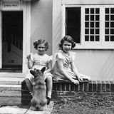 Die Prinzessinnen Elizabeth und Margaret spielen 1936 mit einem Corgi