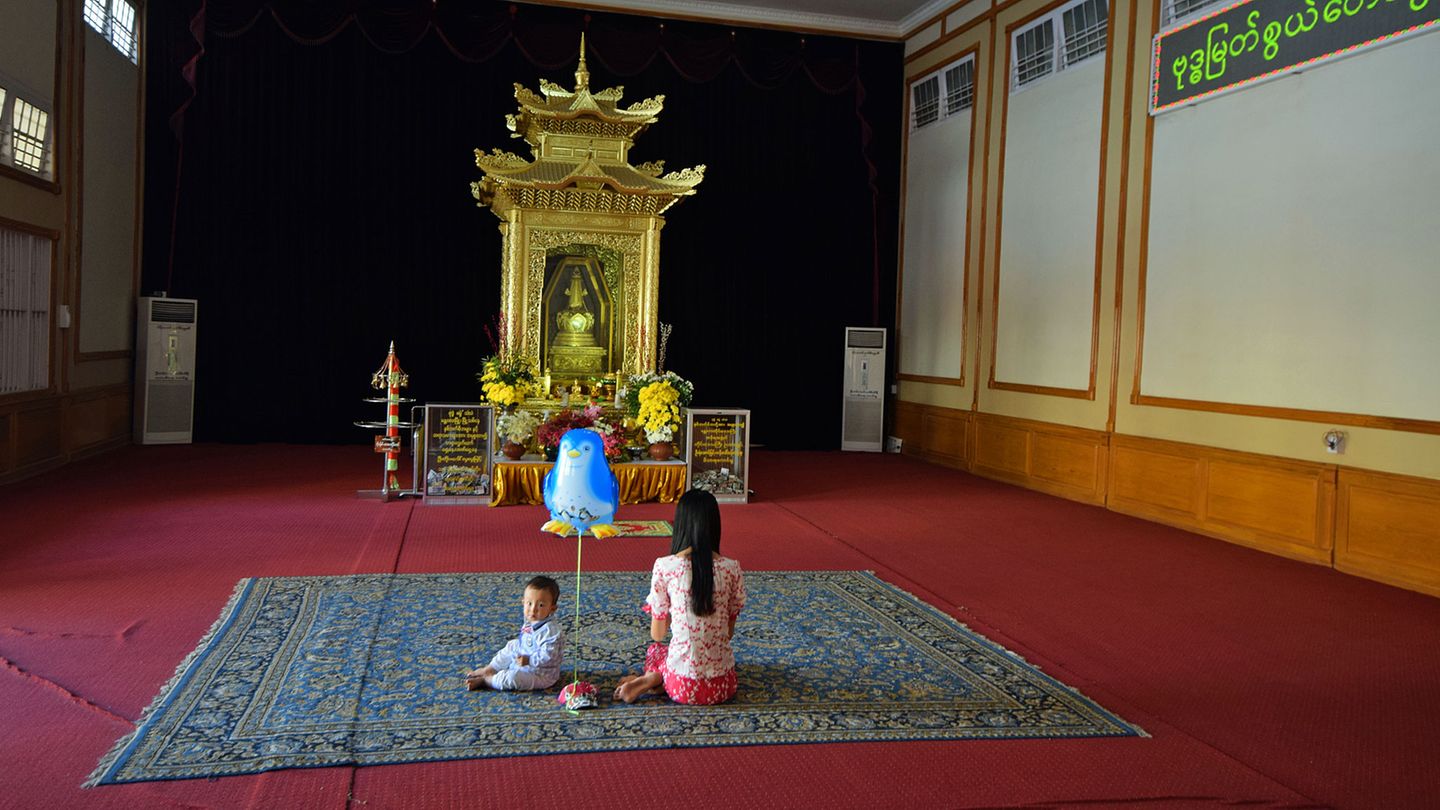 Mutter und Kind vor Buddha-Schrein