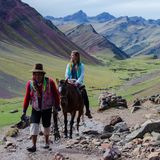 Muli mit Touristin in Berglandschaft