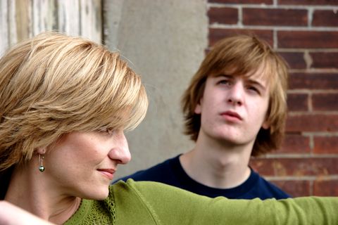 Seitenansicht einer blonden Frau, ein pubertierender Junge starrt in den Himmel