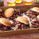 Beef Brisket (für Einsteiger)  Die Variante bietet die Möglichkeit, die Rinderbrust am frühen Vormittag zuzuberieten und sie bereits zum Abendessen fertig zu haben. Normalerweise brauchte eine gut 6 kg schwere Rinderbrust bis zu 16 Stunden.        Rezept für Beef Brisket  Für 10 Personen  Zubereitungszeit: 30 Min.  Garzeit: 6-7 Stunden  Ruhezeit: 2-3 Stunden  Zubehör: Räuchergrill (Water Smoker), Sprühflasche mit Wasser, 6-8 große Mesquite-, Eichen- oder Apfelholz-Chunks, digitales Fleischthermometer, extra reissfeste Alufolie, trockene, gut isolierte Kühlbox      Zutaten:  1 ausgelöste Rinderbrust mit Fettauflage (4½–5½ kg Brustspitz, nach US Zuschnitt mit Flat‐ und Point-Stück), nicht pariert    5 EL grobes Meersalz    4 EL frisch gemahlener schwarzer Pfeffer    500ml Barbecue­‐Sauce (nehmen Sie Ihre Lieblingssauce)    10 Burger­‐Brötchen, aufgeschnitten        Zubereitung:  Den Fettdeckel der Rinderbrust mit einem sehr scharfen Messer gleichmäßig bis auf ½cm  bschneiden (auf keinen Fall das Fett ganz wegschneiden). Das Fleisch umdrehen und die dünne Silberhaut entfernen, sodass das grob gemaserte Fleisch darunter sichtbar wird. Harte Fettklumpen auf beiden Seiten der Brust abschneiden.    2. Salz und Pfeffer mischen. Die Rinderbrust gleichmäßig von allen Seiten mit der Würzmischung einreiben. Das Fleisch vor dem Grillen kalt stellen.  3. Den Räuchergrill für indirekte sehr schwache Hitze (etwa 110 °C) vorbereiten.    4. Die Rinderbrust auf beiden Seiten mit Wasser nass sprühen. Die Hälfte der Chunks auf die Glut geben. Sobald Rauch entsteht, die Rinderbrust mit der Fettseite nach unten auf die oberste Ebene in den Räuchergrill legen und den Deckel schließen. Das Fleisch bei indirekter sehr schwacher Hitze etwa 4 Std. räuchern, bis sich eine schön dunkle Kruste gebildet hat, dabei nach 1 Std. die restlichen Holzstücke auf die Glut geben. Die tiefdunkle Farbe der Kruste ist ein sicheres Anzeichen dafür, dass das Fleisch jetzt »versiegelt« ist, d.h. kaum mehr Raucharomen aufnimmt. Für Sie ist das der Zeitpunkt, an dem Sie das Fleisch in Alufolie einwickeln müssen. Die Farbe der Kruste ist dafür der wichtigste Hinweis, sie sollten jedoch zusätzlich mit dem Fleischthermometer die Kerntemperatur messen, die an der dicksten Stelle der Brust 65–70 °C betragen sollte.    5. Die Rinderbrust vom Grill nehmen und auf beiden Seiten erneut mit Wasser besprühen. Anschließend mit der Fettseite nach unten dicht in eine doppelte oder dreifache Lage extra reißfeste Alufolie einwickeln.    6. Die eingepackte Rinderbrust mit der Fettseite nach unten zurück auf die oberste Ebene des Räuchergrills legen. Über indirekter sehr schwacher Hitze und bei geschlossenem Deckel 2–3 Std. weitergaren, bis sich das in Folie gewickelte Fleisch auf Fingerdruck weich wie ein Riesen-Marshmallow anfühlt und die Kerntemperatur zwischen 90 und 95 °C liegt (die Mürbheit des Fleisches zeigt den richtigen Gargrad jedoch besser an als die Kerntemperatur). Bitte bedenken Sie dabei, dass die Garzeit auch von der verwendeten Rinderrasse und anderen Eigenschaften des Fleisches abhängt.     7. Die Rinderbrust in der Folie vom Grill nehmen und in eine trockene, gut isolierte Kühlbox legen.  Die Kühlbox schließen und das Fleisch etwa 2–3 Std. nachziehen lassen.  8. Danach die Rinderbrust auf einem Schneidbrett vorsichtig aus der Folie wickeln und den kostbaren Fleischsaft in der Folie auffangen.  9. Die Barbecue-Sauce bei mittlerer Stufe auf dem Herd etwa 5 Min. erwärmen. Die Rinderbrust quer zur Faser in dünne Scheiben schneiden und warm mit der Sauce servieren. Nach Belieben den aufgefangenen Fleischsaft vorher noch in die Sauce rühren. Sollte das Fleisch des Flat-Stücks etwas trocken sein, zerpflücken Sie es grob und mischen Sie es nach Geschmack mit Barbecue-­Sauce. Anschließend warm in den Brötchen servieren.