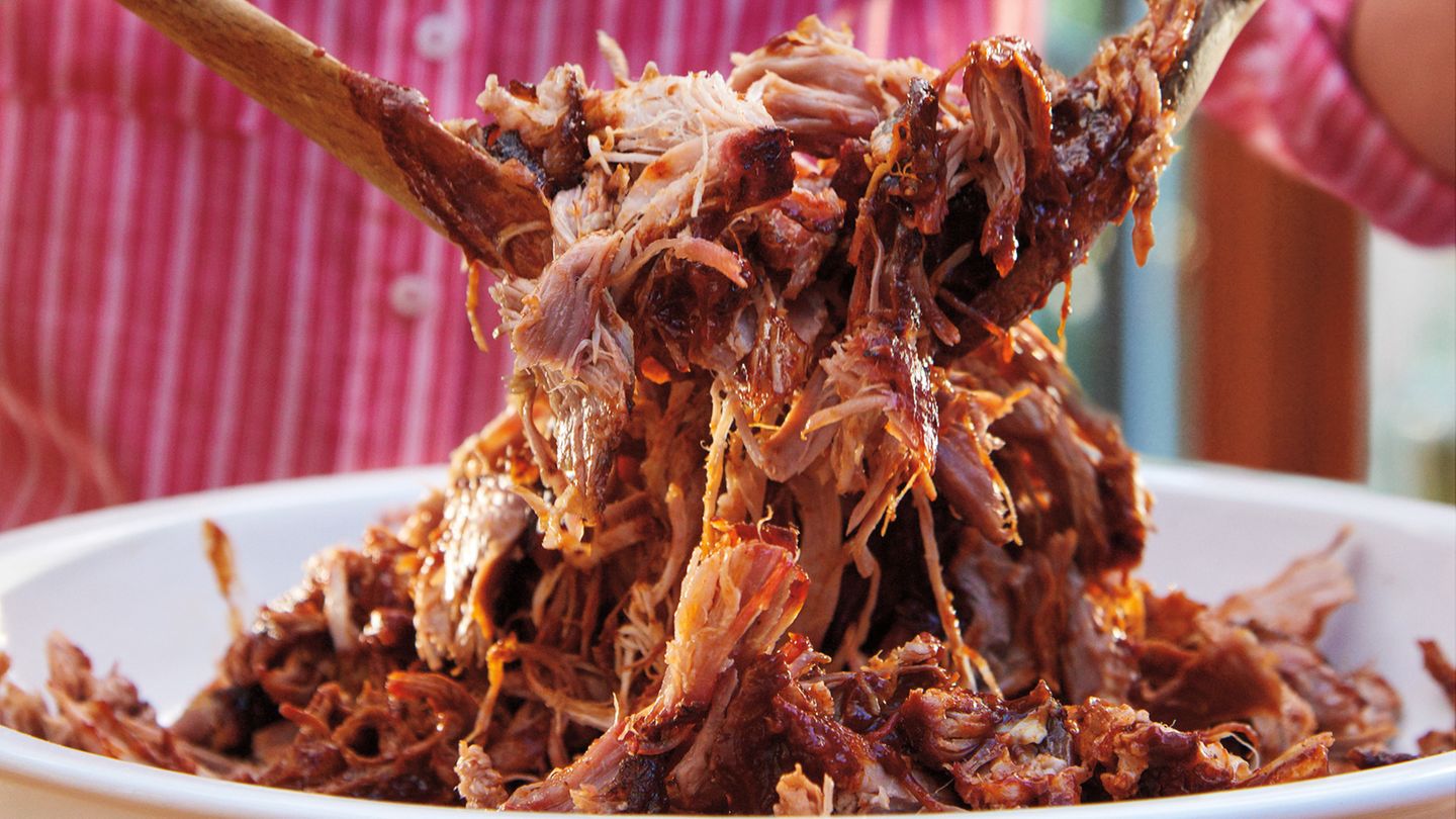 Pulled Pork Kansas-City-Style  Für 10-12 Personen  Zubereitungszeit: 30 Min.    Grillzeit: etwa 5,5 Stunden    Ruhezeit: 1 Stunde    Zubehör: Holzkohlegrill, 4 große Apfel-, Kirsch- oder HIckoryholz-Chunks, große Einweg-Aluschale, Sprühflasche mit Wasser, extra reißfeste Alufolie, digitales Fleischthermometer      Zutaten:  FÜR DIE WÜRZMISCHUNG    110 g Rohrohrzucker    4 EL geräuchertes Paprikapulver    4 TL grobes Meersalz    2½ TL Chilipulver    2½ TL Knoblauchpulver    2½ TL Zwiebelpulver    1 ½ TL grob gemahlener schwarzer Pfeffer    ½–1 TL Cayennepfeffer        2 kg ausgelöster Schweineschulterbraten (Boston-Butt-Zuschnitt, d. h. mit Nackenstück), überschüssiges Fett und Silberhaut entfernt        FÜR DIE SAUCE    3 Scheiben Frühstücksspeck    ½ mittelgroße Zwiebel, fein gewürfelt    3 Knoblauchzehen, fein gehackt    120 ml Ketchup    120 ml heller Zuckersirup    120 ml Apfelessig    4 EL Tomatenmark    4 EL Chilipulver    2 EL Rohrohrzucker    1 EL Zuckerrohrmelasse    1 EL Worcestersauce    1 TL Selleriesalz    ½ TL grobes Meersalz        Zubereitung:  1. Die Zutaten für die Würzmischung vermengen und den Braten damit rundherum bestreuen. Vor dem Grillen bei Raumtemperatur 30 Min. ruhen lassen.    2. Den Grill für indirekte sehr schwache Hitze (110–120 °C) mit der Minion-Ring- Methode vorbereiten (eine Anleitung finden Sie auf Seite 76). Sobald die Temperatur im Grill 110 °C erreicht hat, das Fleisch mit der Fettseite nach unten auf den Grillrost legen und über indirekter sehr schwacher Hitze bei geschlossenem Deckel 4 Std. grillen, dabei mithilfe der oberen Lüftungsschieber die Temperatur so konstant wie möglich bei 110 °C halten. Den Braten nach 1 Std. Garzeit mit etwas Wasser besprühen und dies dann jede Stunde wiederholen.  3. In der Zwischenzeit die Sauce zubereiten. Den Speck in einem mittelgroßen Topf mit schwerem Boden auf mittlerer Stufe braten, bis das meiste Fett ausgelassen ist. Mit einem Schaumlöffel herausheben und gleich an Ort und Stelle verspeisen oder für eine andere Verwendung aufbewahren. Das ausgelassene Fett im Topf bis auf 2– 3 EL abgießen, dann die Zwiebel im heißen Speckfett in 3–4 Min. glasig dünsten, dabei ab und zu umrühren. Den Knoblauch unter gelegentlichem Rühren 1 Min. mitdünsten. Die übrigen Zutaten für die Sauce einrühren und auf mittlerer Stufe 10– 15 Min. köcheln lassen, dabei ab und zu umrühren. Vom Herd nehmen und abkühlen lassen. Die Sauce im Mixer glatt pürieren und anschließend aufteilen: Eine Hälfte ist zum Befeuchten des Bratens, bevor er in Folie gewickelt wird. Die andere Hälfte wird später unter das Pulled Pork gemischt.  4. Nach 4 Std. Garzeit sollte der Braten eine Kerntemperatur von 70 °C haben, andern-falls muss er noch weitergaren. Das Fleisch vom Grill nehmen und den Deckel sofort wieder schließen.    5. Auf einer großen Arbeitsfläche zwei 1 m lange Bögen extra reißfeste Alufolie kreuzförmig übereinanderlegen. Den Braten mit der Fettseite nach oben in die Folienmitte legen und oben und an den Seiten dünn mit Sauce bestreichen. Zuerst die Enden des inneren Folienbogens über dem Braten zusammenfalten, dann den Braten fest in den äußeren Folienbogen einwickeln, damit kein Dampf austreten kann. Zurück auf den Grillrost legen und über indirekter sehr schwacher Hitze bei geschlossenem Deckel so lange weitergrillen, bis der Braten nach etwa 1 ½ Std. eine Kerntemperatur von 88–90 °C hat. Vom Grill nehmen und 1 Std. in der Alufolie nachziehen lassen.    6. Den Braten auswickeln, etwas abkühlen lassen, dann das Fleisch zerpflücken. Größere Fettstücke und Sehnen entfernen und wegwerfen. Das Pulled Pork mit Sauce mischen und sofort servieren.