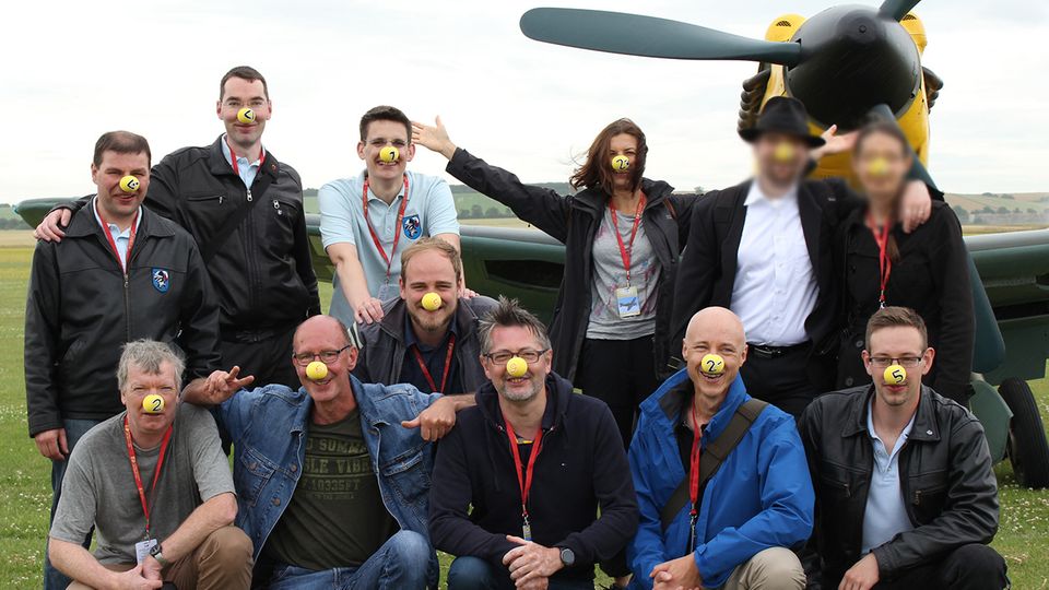 Virtuelle Luftschlacht um England : Die internationale Community der virtuellen Flieger trifft sich regelmäßig auf Airshows wie hier im britischen Duxford 2016. Man erkennt sich am "Vereinsshirt". Diese Gruppe trägt zum Spaß gelbe Nasen - wie die im Hintergrund stehende Messerschmitt 109 einst in der Luftschlacht um England. Die internationale Community der virtuellen Flieger trifft sich regelmäßig auf Airshows wie hier im britischen Duxford 2016. Man erkennt sich am "Vereinsshirt". Diese Gruppe trägt zum Spaß gelbe Nasen - wie die im Hintergrund stehende Messerschmitt 109 einst in der Luftschlacht um England.