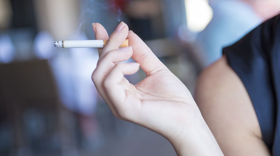 Zehn Tipps, um mit dem Rauchen aufzuhören Eine Frau hält eine Zigarette in der Hand